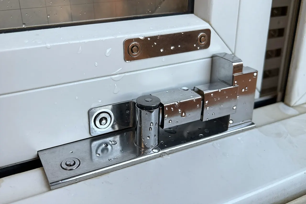 Detail of a casement window handle and friction hinge