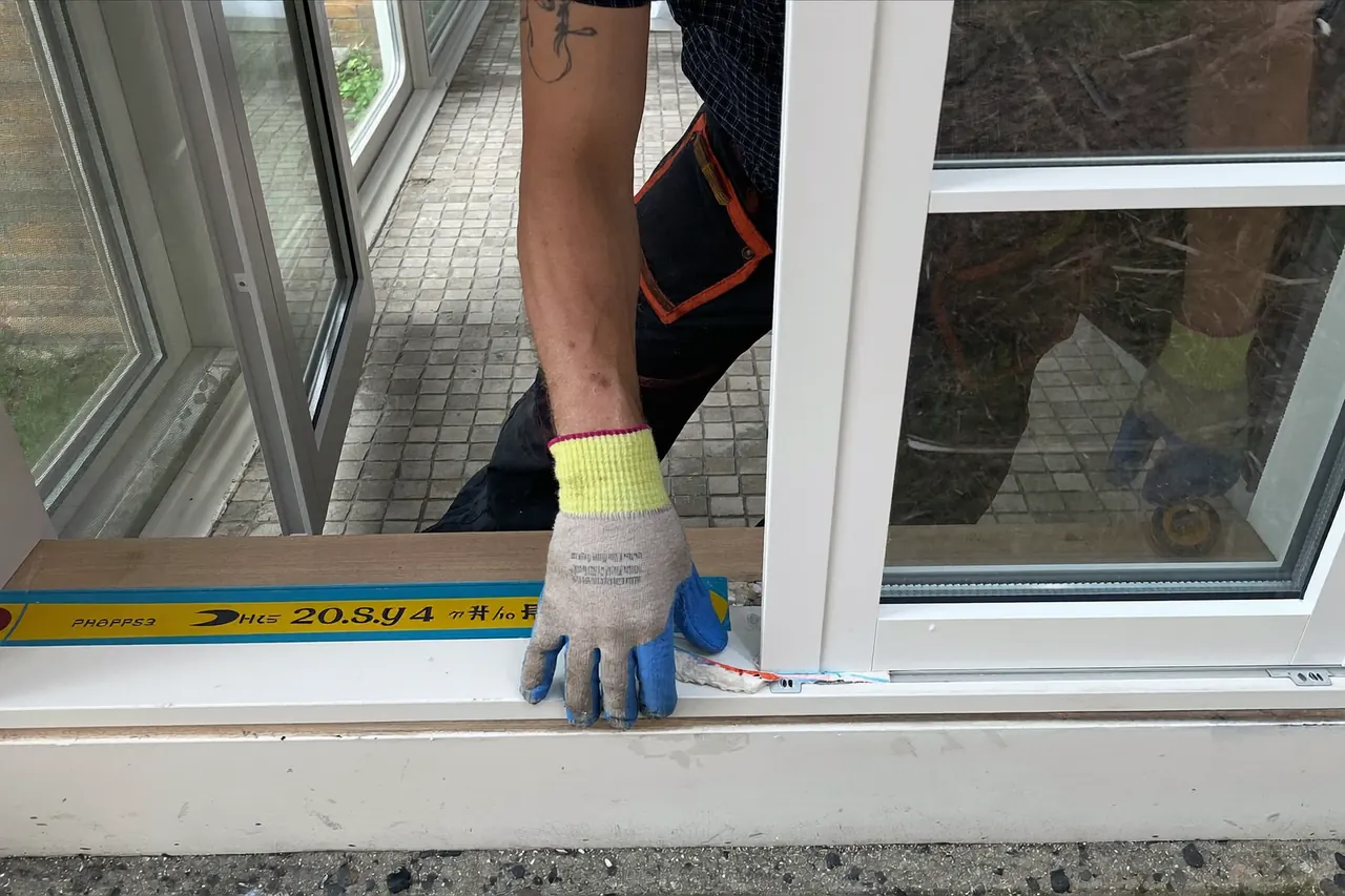 An installer fitting a casement window in a UK home