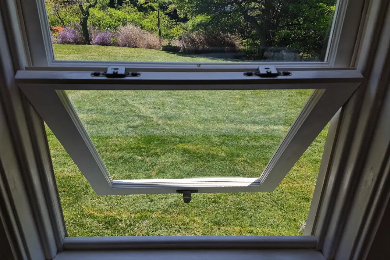 A side-hung casement window open onto a garden
