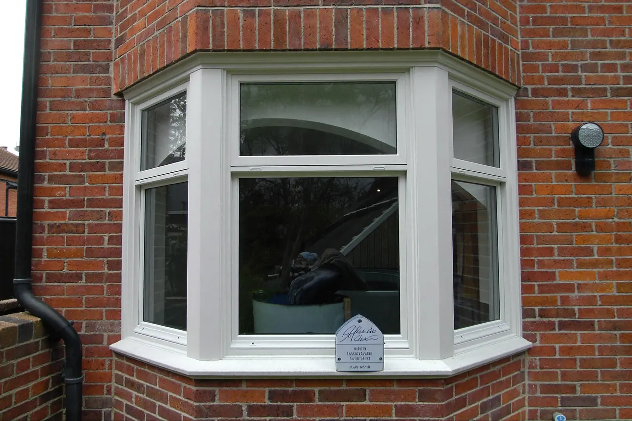 White uPVC casement windows in a bay on a red-brick house